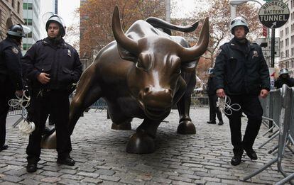 Varios policías protegen al toro de Wall Street, ante el avance de los manifestantes.