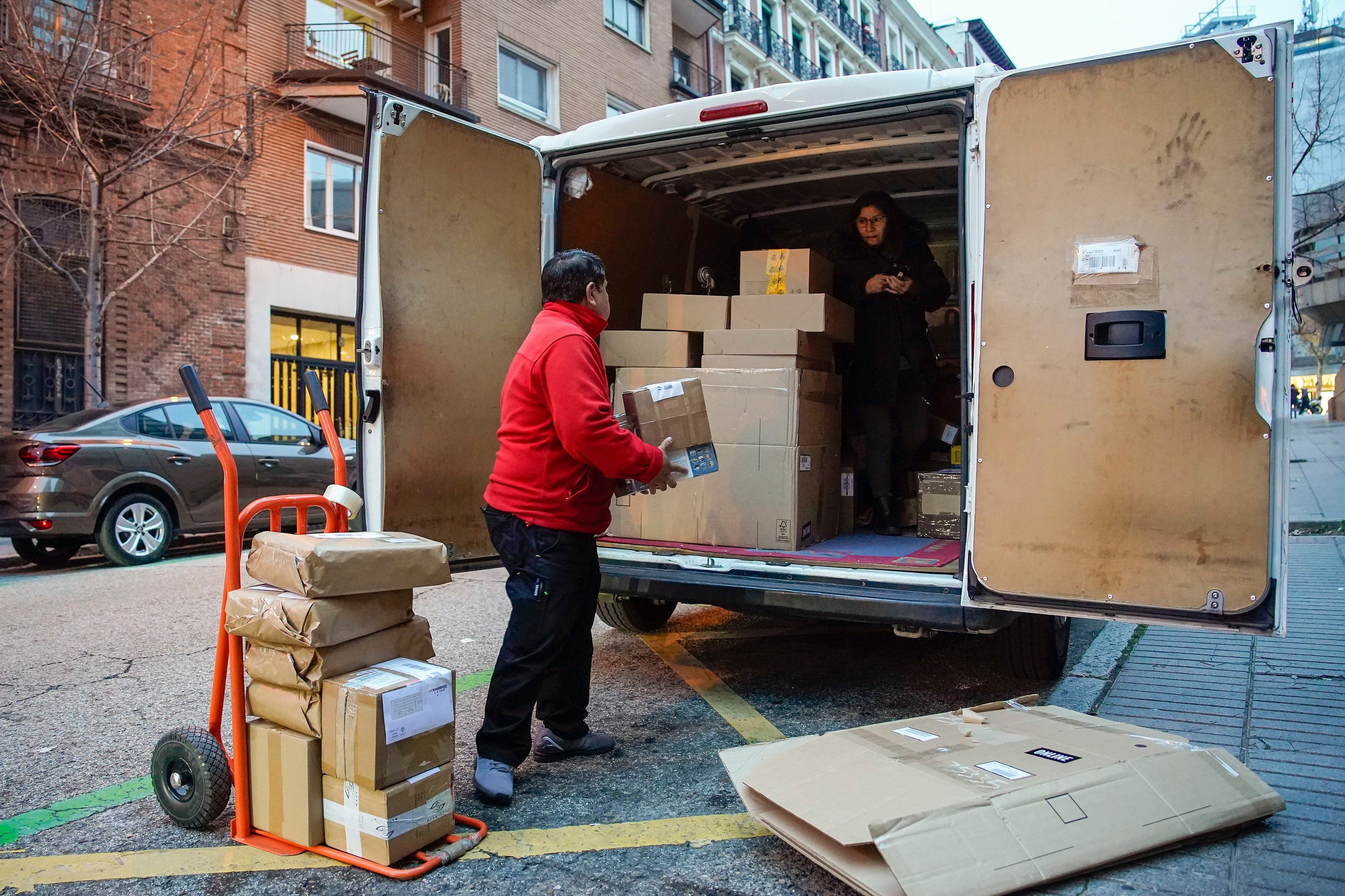 El repartidor Amado López y su esposa Mónica meten paquetes en la furgoneta de reparto durante el trabajo en Madrid. 