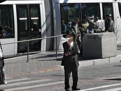 Jud&iacute;os ultraortodoxos ante una parada del tranv&iacute;a de Jerusal&eacute;n.