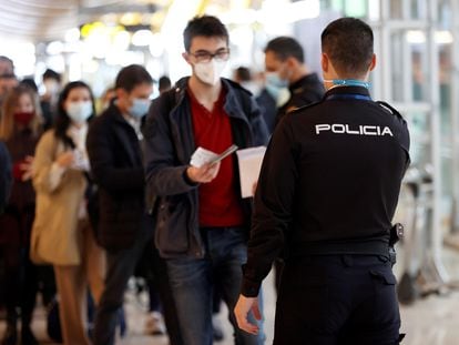 Un policía controla el paso de viajeros en el aeropuerto Adolfo Suárez-Madrid Barajas, el pasado viernes.
