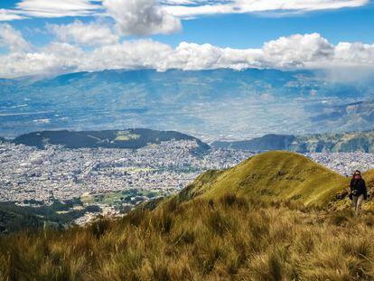 Una senderista subiendo al Pichincha (4.784 metros), uno de los volcanes andinos que rodean la ciudad de Quito, al fondo. 