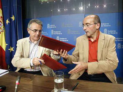 Miguel Sanz (a la izquierda) intercambia con Juan Cruz Alli (CDN) los documentos del acuerdo de gobierno.