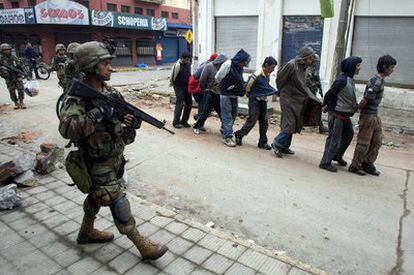 Un soldado chileno vigila a un grupo de personas detenidas en la localidad de Talcahuano