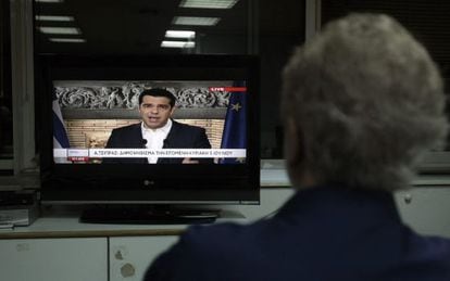 Un home veu el missatge televisat de Tsipras. 