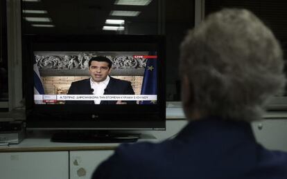 Un home veu el missatge televisat de Tsipras.