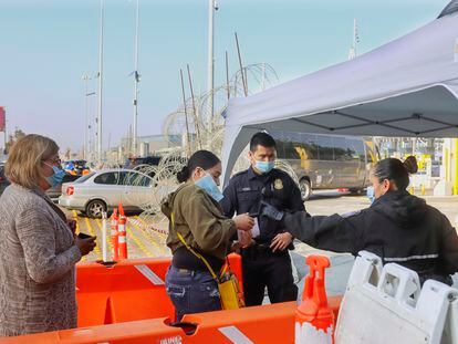 Una mujer muestra su cartilla de vacunación a autoridades estadounidenses en un paso fronterizo en Tijuana, en noviembre de 2021.