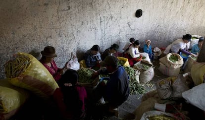 Mujeres que separan grano en el Mercado de San Roque. Ellas solían trabajar durante la madrugada, entre 8 y 10 horas, para llenar los sacos por los que luego cobran entre unos cinco dólares. Ahora deben esperar que pase el toque de queda para llegar al mercado, lo que les deja menos tiempo para faenar y esto significa menos dinero.
