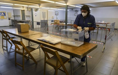 Una trabajadora desinfecta una urna electoral en el colegio Verd, en Girona. Dos centros de repetición de telecomunicaciones han sido saboteados la pasada noche en Girona y Lleida, horas antes de la jornada electoral que vive este domingo Cataluña.