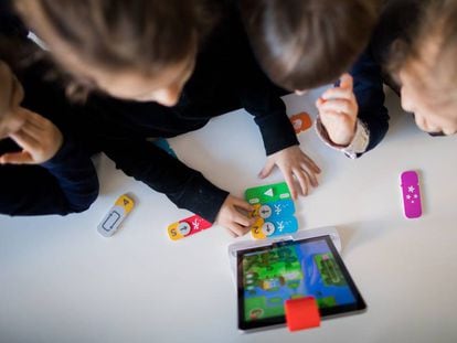 Niños en una guardería alemana aprendendiendo a programar con un iPad ejecutando comandos de bloques.