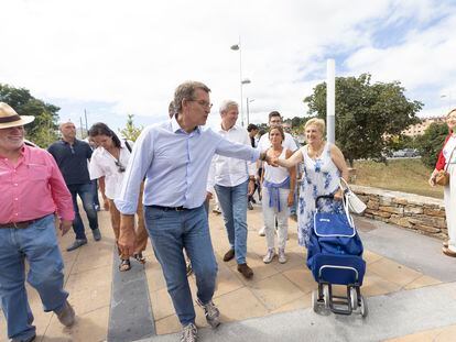 El presidente del Partido Popular, Alberto Núñez Feijóo, saluda a una vecina mientras hace un tramo del Camino Portugués, a 25 de agosto de 2022, en Pontevedra.
