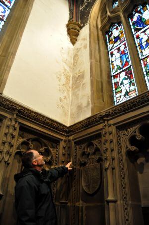 El párroco de la iglesia de Haworth señala las humedades de las paredes.