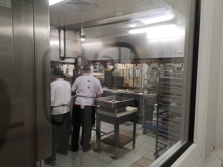 Dos empleados en las cocinas centrales de Ifema, en Madrid, desde donde la empresa Eurest prepara la comida del Hospital de Emergencias Isabel Zendal.