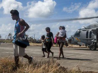 Varios afectados por el tifón en Filipinas, llegan a una zona más segura en Guiuan, tras ser trasladados por la Marina estadounidense. 