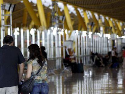 Varios viajeros en el aeropuerto Adolfo Su&aacute;rez Madrid-Barajas.