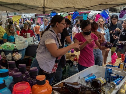 Dos mujeres preparan bebidas alcohólicas en el 'tianguis' de la Lagunilla, en Ciudad de México, el 8 de agosto de 2022.