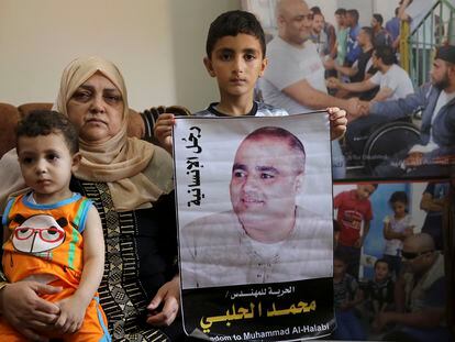 La madre del cooperante palestino condenado en Israel, y dos de los hijos de Mohamed Halabi (en el cartel), en 2016 en Gaza.