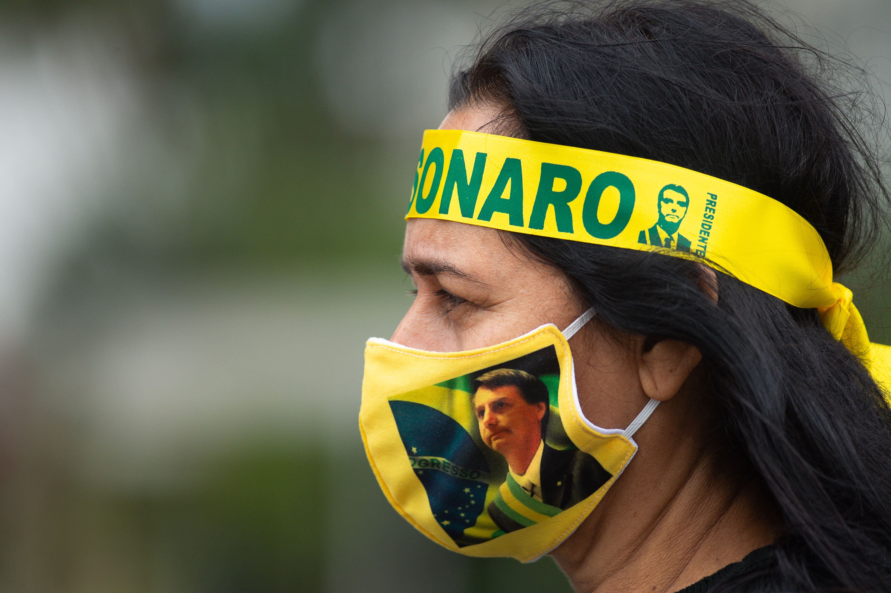 Una partidaria de Jair Bolsonaro usa un cubrebocas con el rostro del presidente brasileño, en mayo de 2020 en Brasilia. 