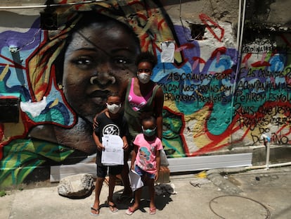 Janice Delfim, fundadora de una iniciativa para facilitar el acceso a la educación de los niños perjudicados por el cierre de escuelas por la covid-19, posa con dos de las beneficiarias de su proyecto, en la favela Prazeres de Río de Janeiro, en Brasil.