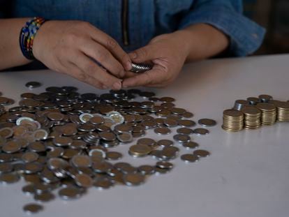 Una trabajadora cuenta dinero en una tienda, en Tetecala, Morelos, el 4 de febrero de 2022.