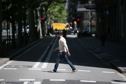 Un hombre cruza el carril lateral de la Gran Via de Barcelona, donde se cortará el tráfico para dar espacio a los peatones.