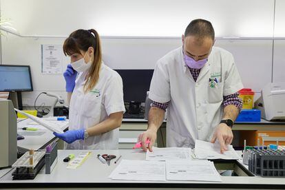 Dos sanitarios del laboratorio del Hospital Clínic de Barcelona gestionan los resultados de las analíticas de forma manual tras el ciberataque al centro sanitario.