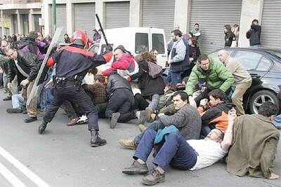 Agentes de la Ertzaintza cargan contra la manifestación, que finalmente llegó a Portugalete.