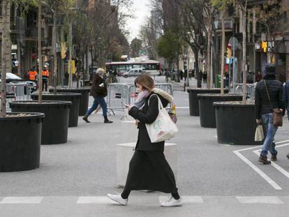 Una jove passeja per l'encreuament dels carrers Marina i Mallorca, al costat de la Sagrada Família.