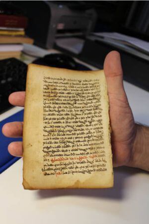 La hoja del códice con texto médico en manos del catedrático de la UCO Juan Pedro Monferrer.