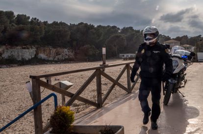 Un policía patrulla por la playa s'Estany d'en Mas, en Manacor, este lunes.