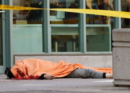 Un cuerpo cubierto en la acera donde una camioneta ha atropellado a numerosos peatones en Toronto.