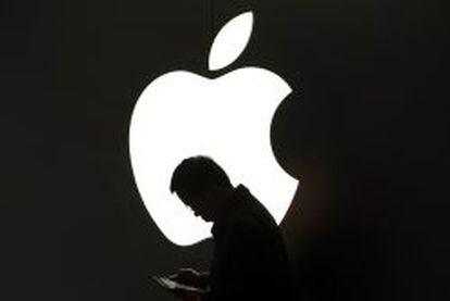 Un hombre lee junto a un logotipo de Apple