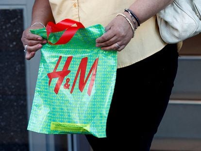 FILE PHOTO: A woman holds an H&M bag after shopping at an H&M clothing store in Hollywood, California January 26, 2011. REUTERS/Fred Prouser/File Photo