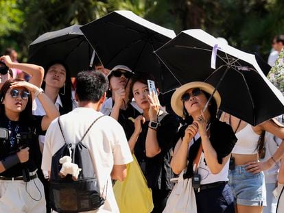 Varios turistas equipados con sombrillas visitan la Sagrada Familia, en una imagen de este verano.