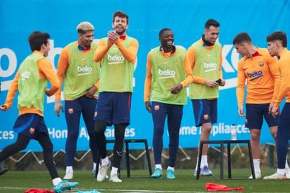 Dembélé, entre Piqué y Busquets, sonríe en el entrenamiento de ayer del Barça.