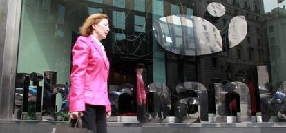 Foto de mujer pasando por sucursal de Liberbank.