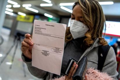 Una pasajera procedente de un vuelo de Colonia (Alemania) muestra el resultado negativo de su PCR tras aterrizar en el Aeropuerto de Palma de Mallorca.