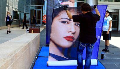 Un operario coloca el cartel de Selena Quintanilla en la tienda de MAC de Corpus Christi, Texas.