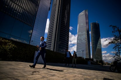 Un hombre con traje pasea por la zona la de las cuatro torres del Paseo de la Castellana, en Madrid, en 2019.