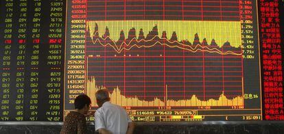 Dos inversores frente a los paneles de la Bolsa de Shangái