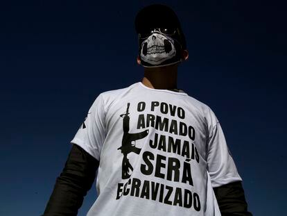 Un hombre usa una camiseta con la leyenda "el pueblo armado nunca será esclavizado", durante una protesta a favor de las armas, en Brasilia.