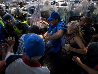 Manifestantes se enfrentan a policías durante una protesta en la que piden mejoras salariales, en Caracas.