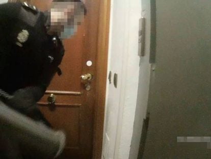 Uno de los policías imputados en el momento de golpear con un ariete la puerta del piso de la calle Lagasca de Madrid en la que se celebraba una fiesta ilegal, en marzo de 2021.