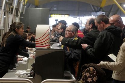 Un grupo de afectados por la protesta de los controladores reclamando en el mostrador de una compañía aérea en la Terminal 4 del aeropuerto madrileño de Barajas.