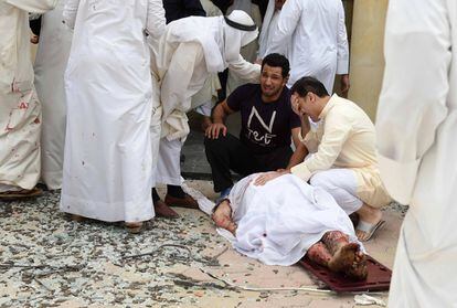 Dos hombres lloran ante el cuerpo sin vida de una de las víctimas del atentado.