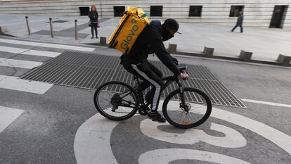 Un ciclista repartidor de Glovo por la Carrera de San Jerónimo de Madrid.