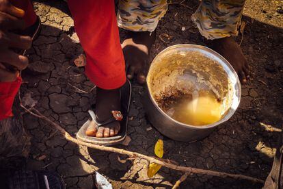 Una olla con agua sucia y restos de alguna comida, en el suelo del descampado de Joda, ya en territorio sursudanés, donde miles de personas aguardan para ser trasladadas a un campo de refugiados. 