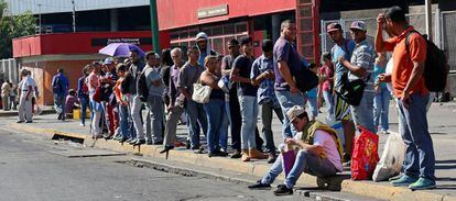 Trabajadores en una parada de autobús de Caracas, Venezuela.