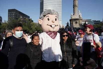 Asistentes a la marcha se fotografían con una botarga de López Obrador.