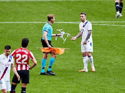 El árbitro Pizarro Gómez retira el dron que aterrizó en el césped de San Mamés
