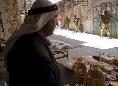 Soldados israelíes patrullan un mercado ayer en la ciudad cisjordana de Hebrón.